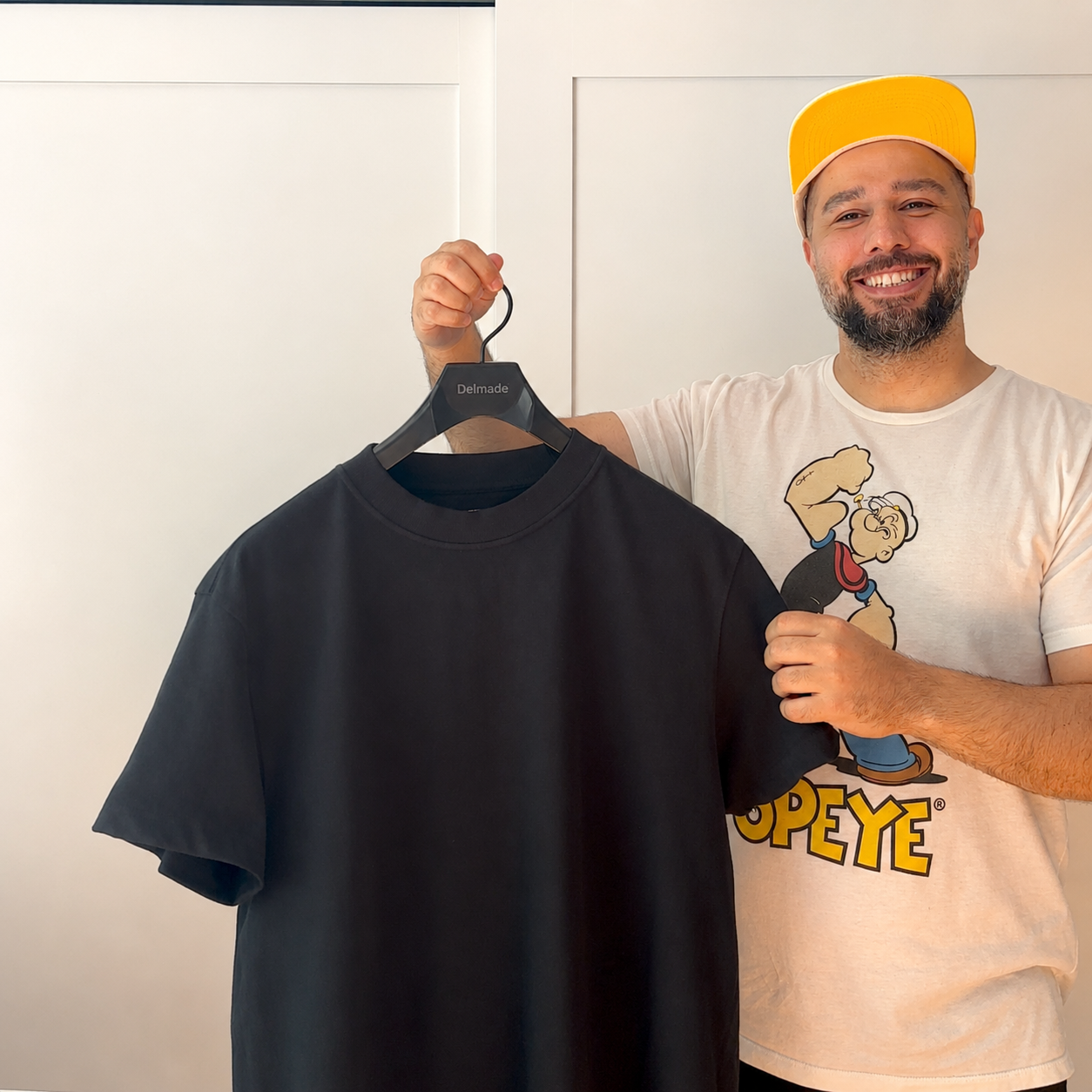 Founder holding the Delmade T-shirt on a hanger