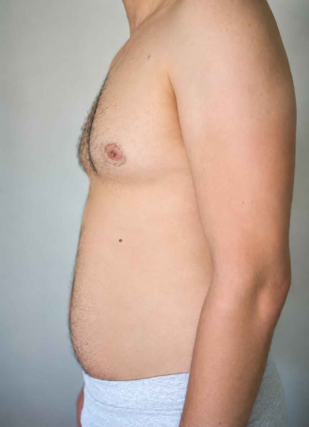 Side profile of an average-build man's torso, showing real body shape